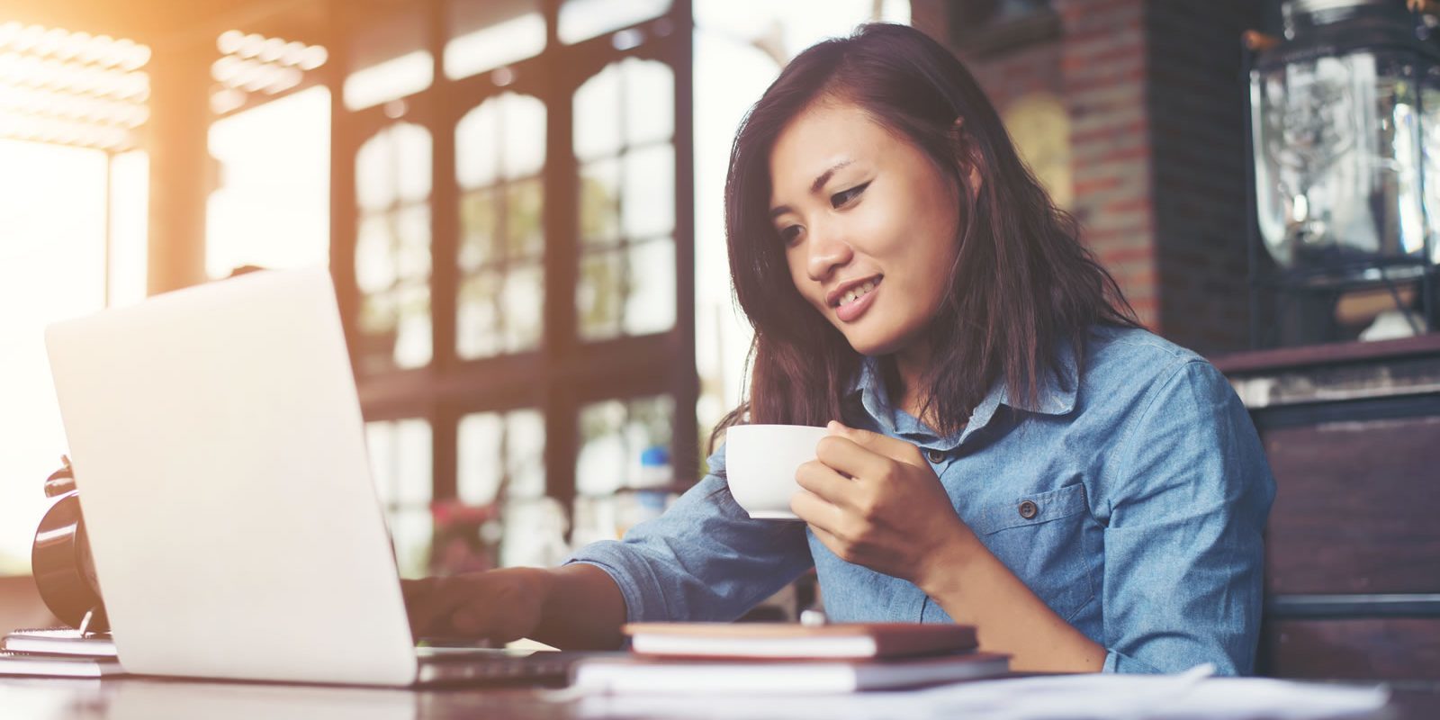 young woman on laptop drinking coffee