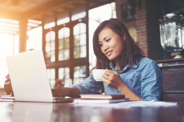 young woman on laptop drinking coffee